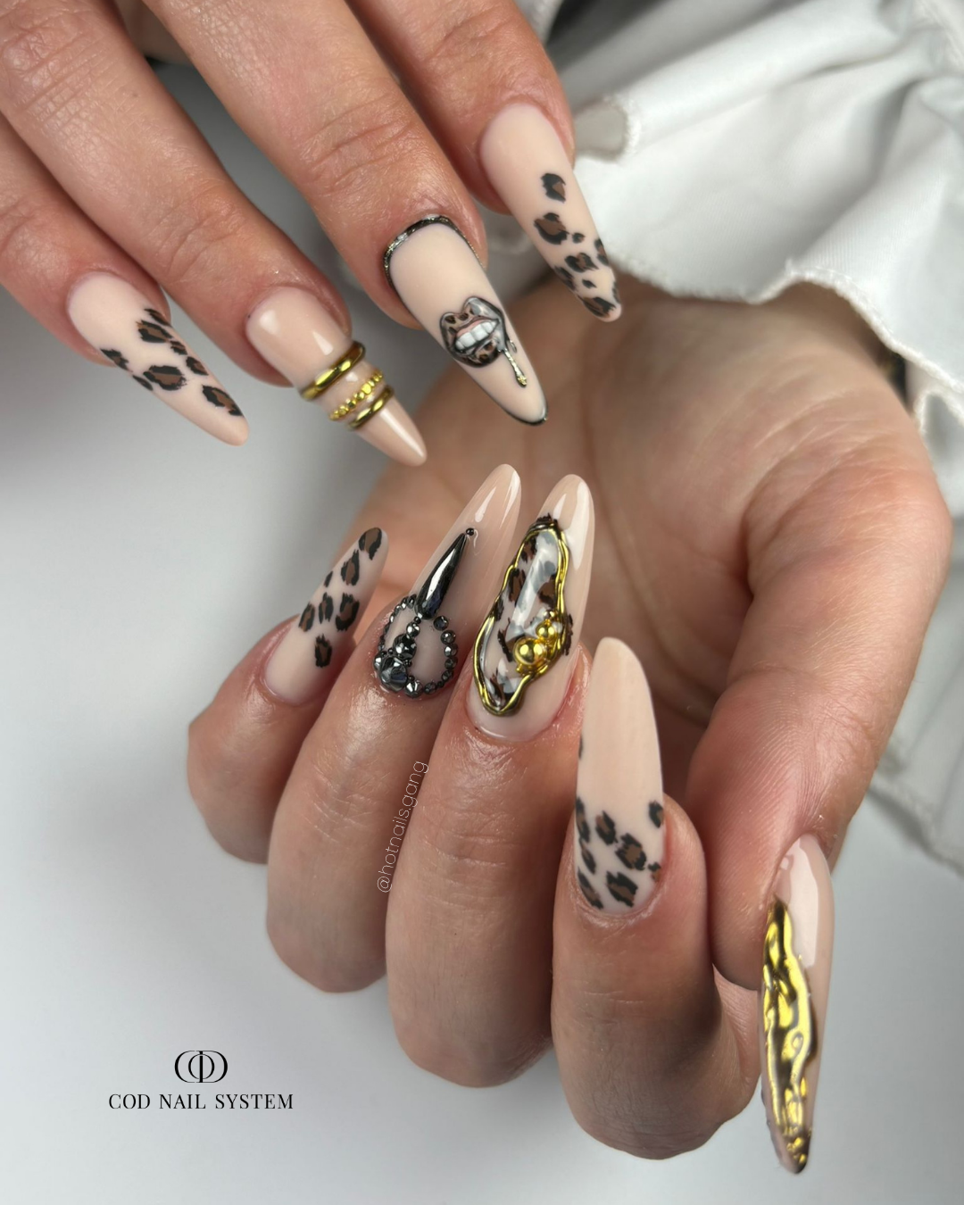 Pose d'ongles en amandes nude beige avec nail art léopard et 3D chrome doré avec strass
