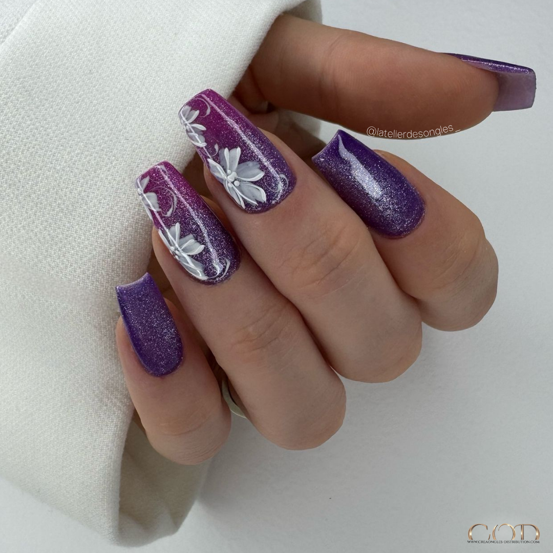 Pose d'ongles coffin dégradés violets avec nail art fleurs