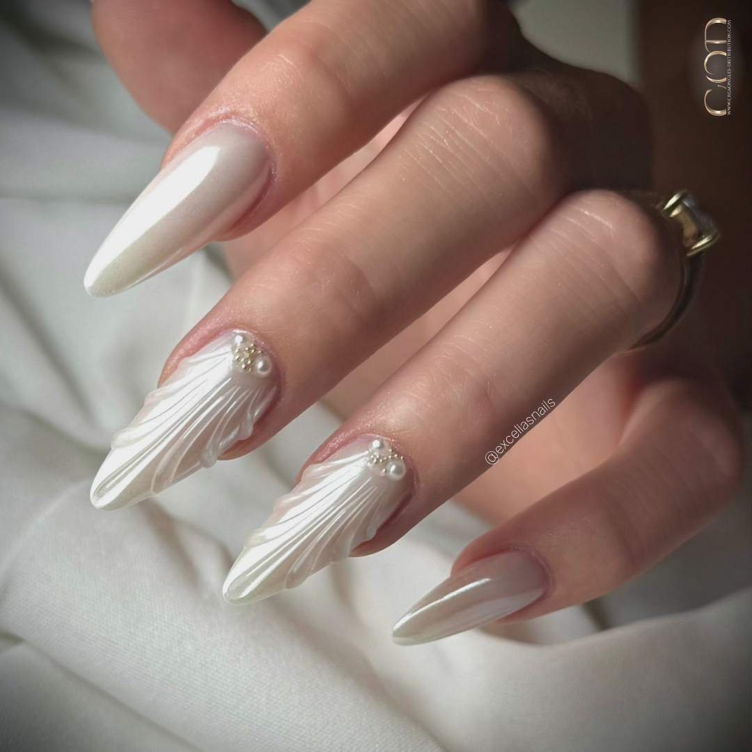 Pose d'ongles en amandes blanc perlés avec nail art 3D coquillage