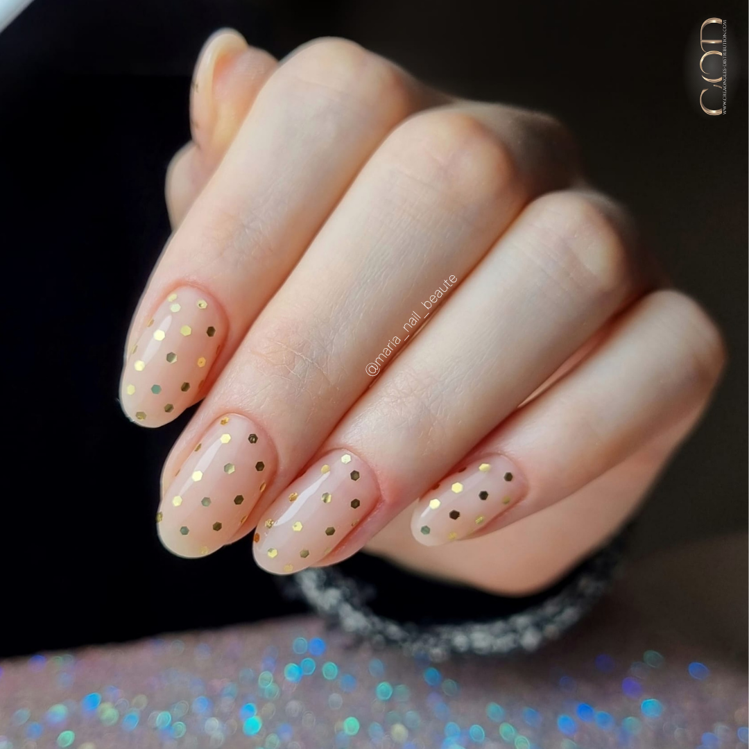 Pose d'ongles ovales nude beige avec pois en paillettes