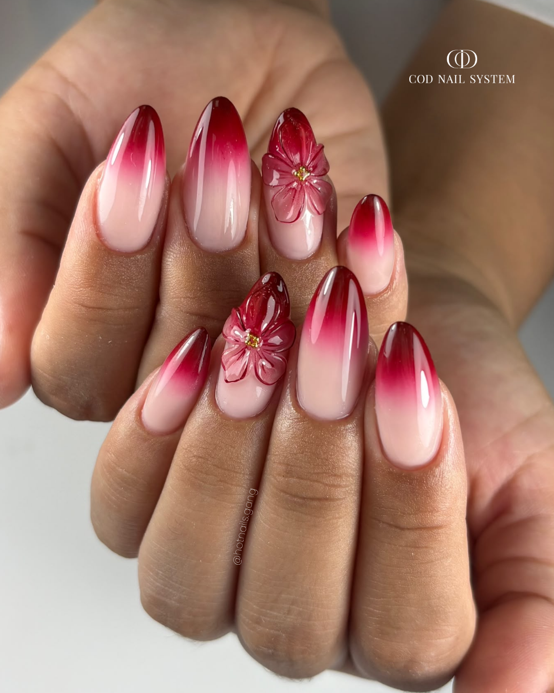 Pose d'ongles amandes bordeaux babycolor et fleur 3D Pose d'ongles amandes avec babycolor dégradé rouge bordeaux et fleurs 3D