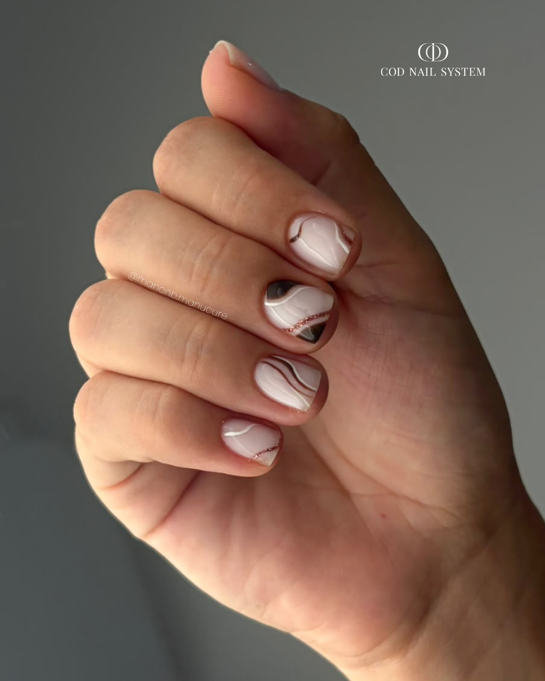 Pose d'ongles courts milky white et marron Pose d'ongles courts milky white avec nail art lignes marron