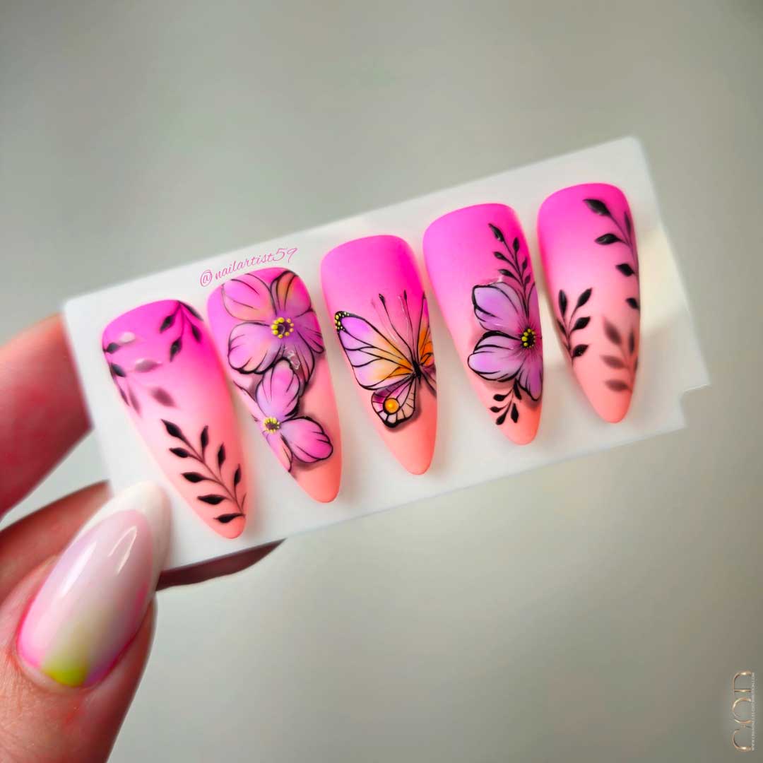Photo de capsules d'ongles colorées avec nails art feuillages, fleurs et papillon